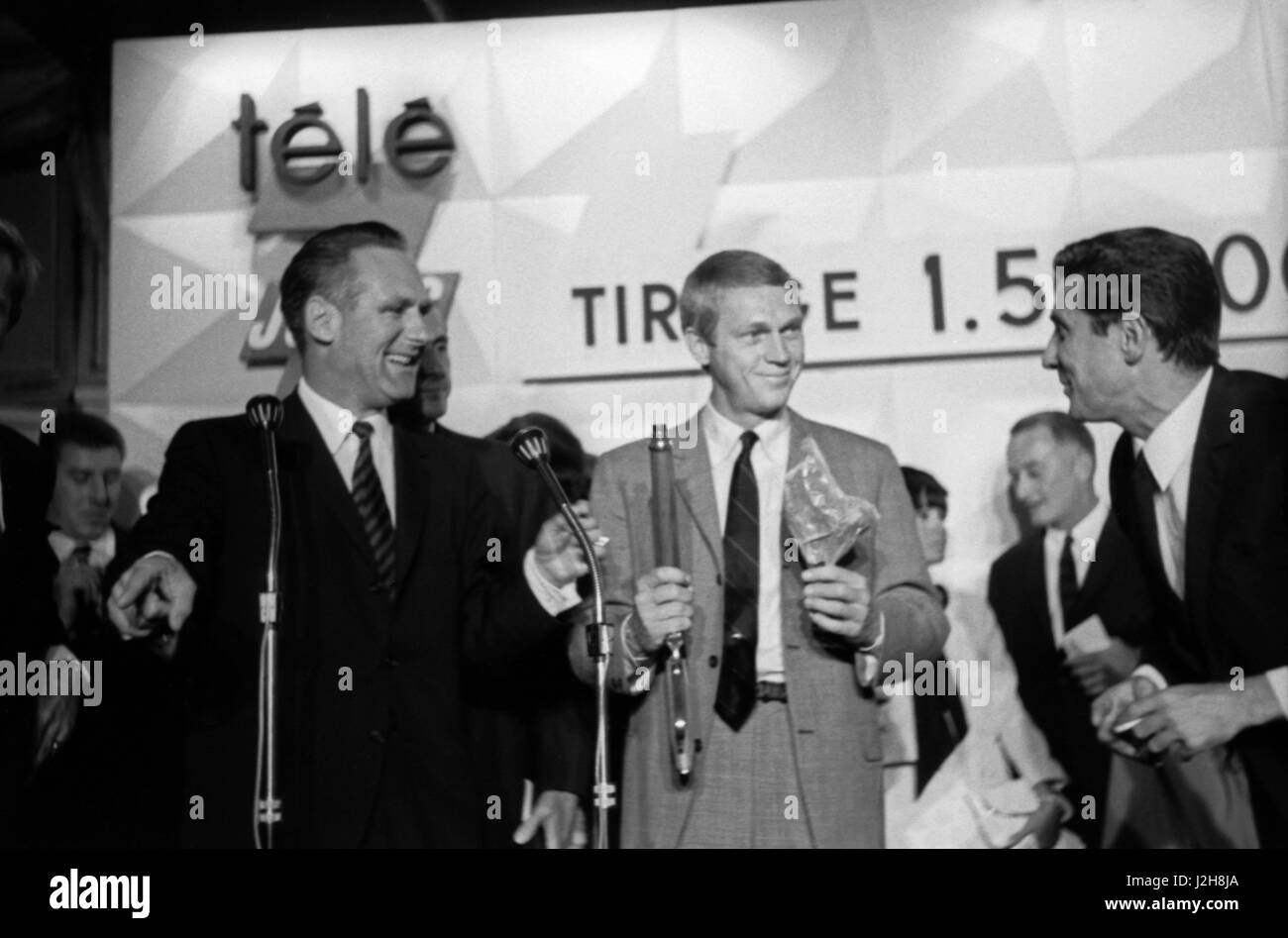Jacques Sallebert und Steve McQueen in der Charity-Auktion wo Gilbert Bécaud (rechts) das Winchester-Gewehr von McQueen in der TV-Serie "Wanted Dead or Alive" verwendet erwarb.  Hotel Ritz in Paris, 1963 Foto André Crudo Stockfoto