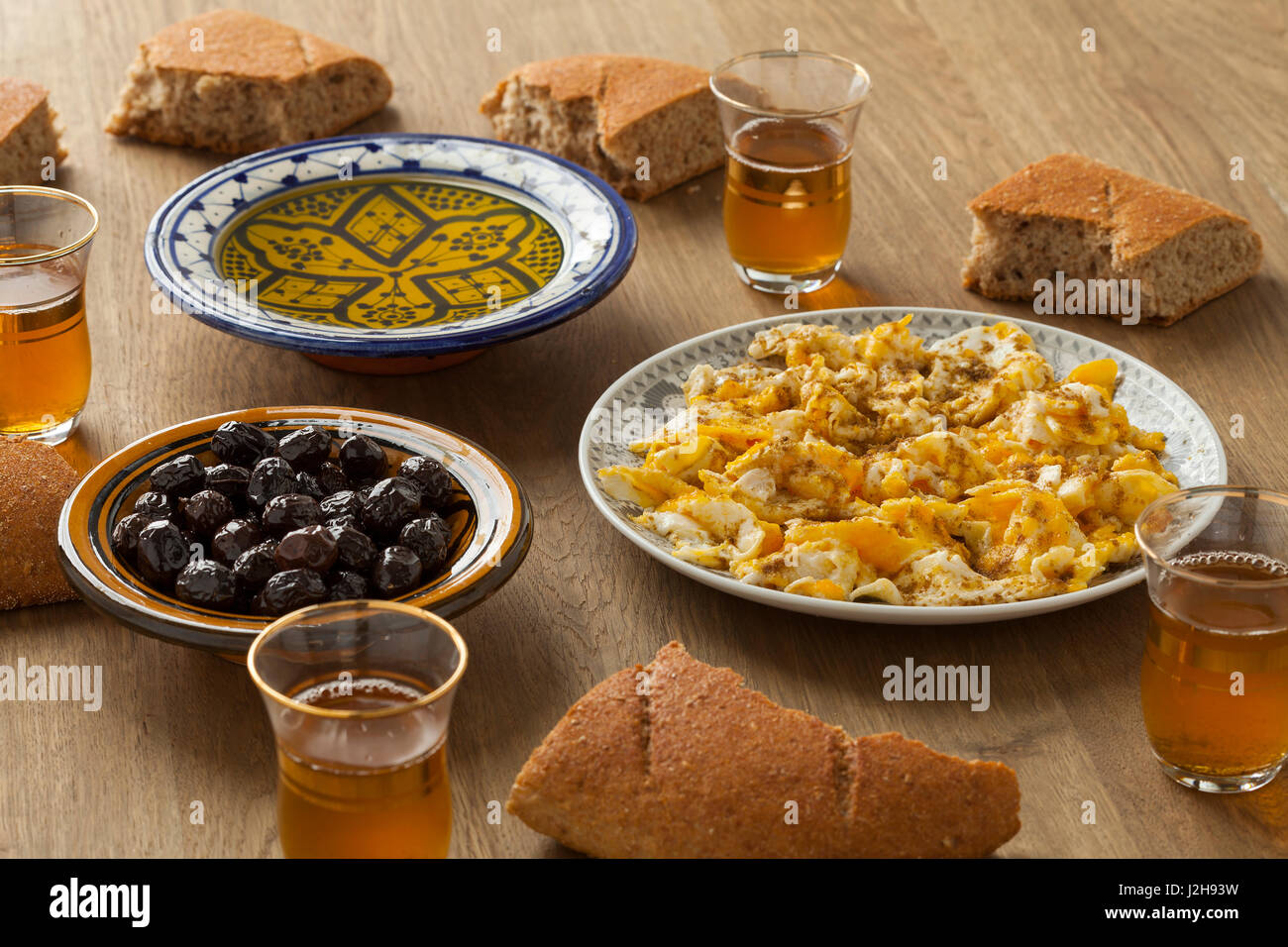 Traditionelles marokkanisches Frühstück mit Brot, Eiern, Oliven, Olivenöl und Pfefferminztee Stockfoto