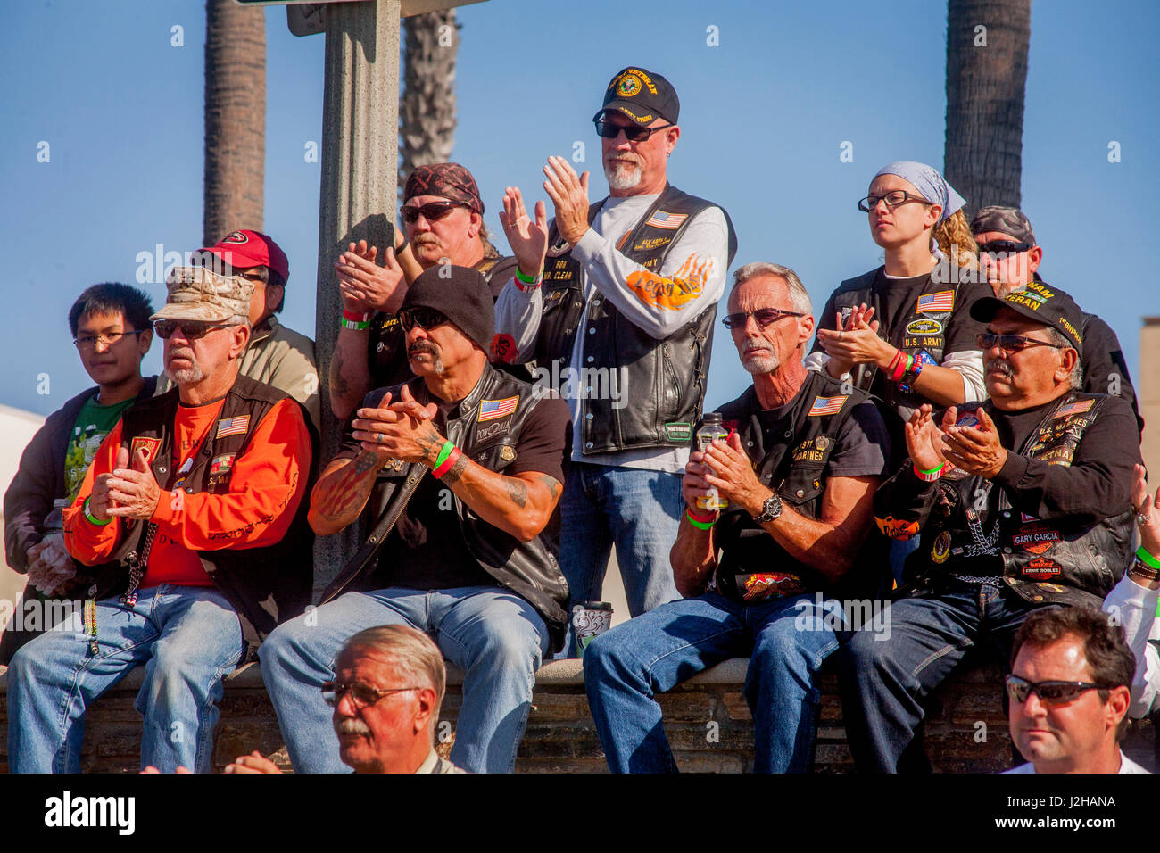 Erfahrene Motorradfahrer applaudieren Redner bei einer Kundgebung in Huntington Beach, CA. Hinweis Jacken und Caps. Stockfoto