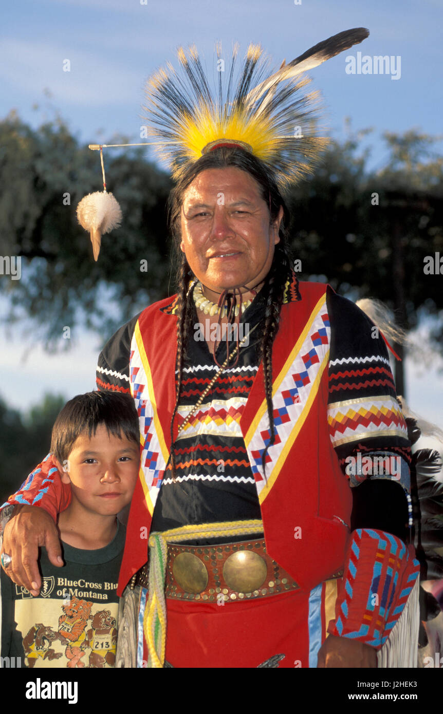 Blackfeet Vater im traditionellen Insignien legt Arm um junge während eines amerikanischen Indianer sammeln im Bitterroot Valley Montana Stockfoto