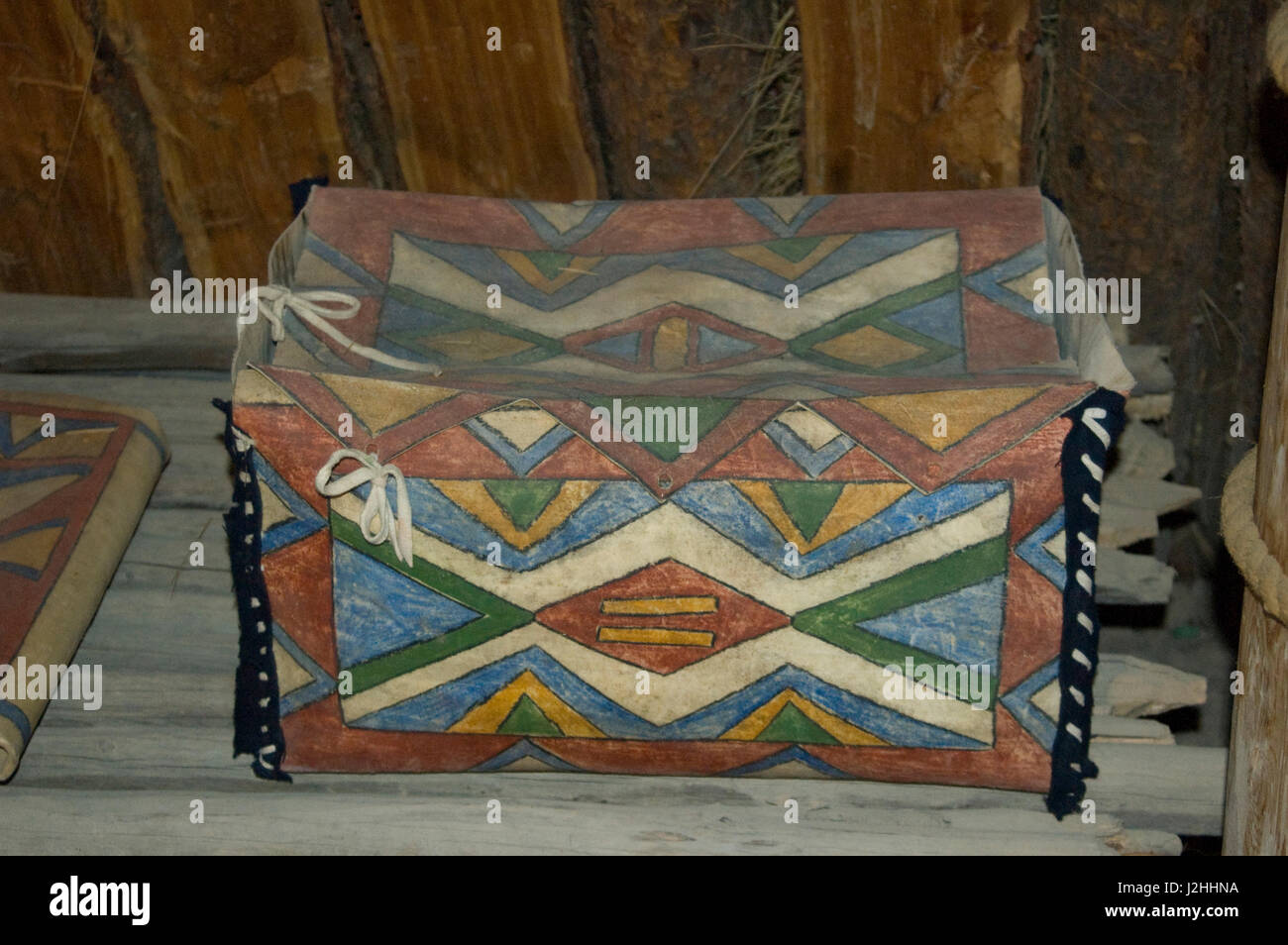 Bemalte Mandan Aufbewahrungsbox hergestellt aus Rohhaut Parfleche auf dem Display in einer irdenen Lodge an der Knife River Indian Village, North Dakota Stockfoto