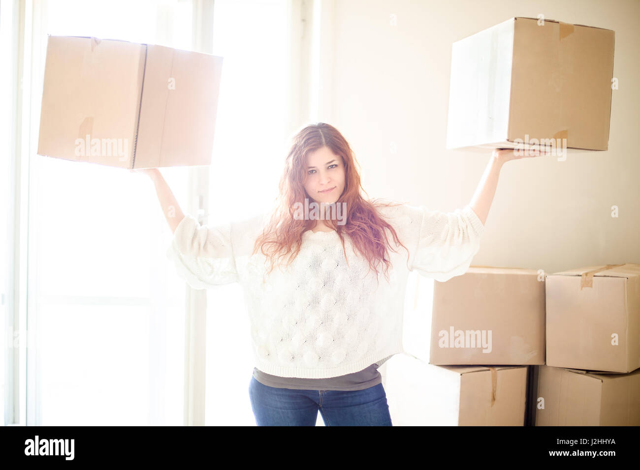 Zuversichtlich, rothaarige Frau Umzug heben zwei Boxen Stockfoto