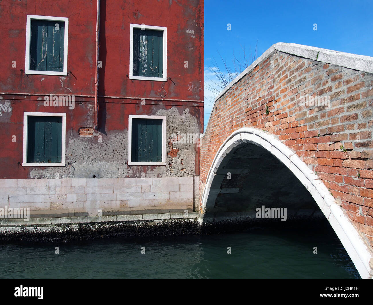 Fußgängerbrücke in Murano Venedig mit roten Gebäude und abblätternde Farbe Stockfoto