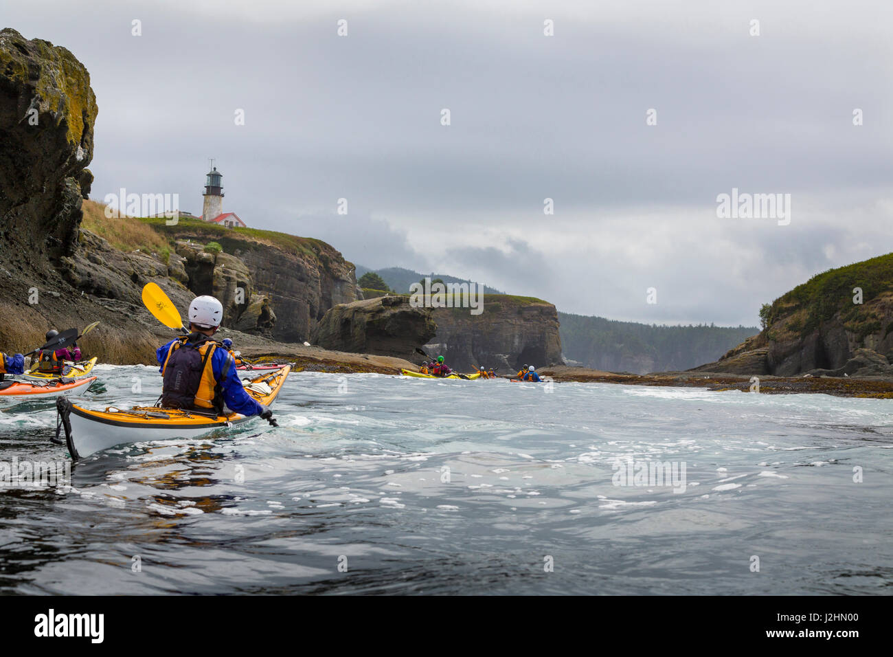 USA, US-Bundesstaat Washington. Kajakfahrer Meer paddeln unter Leuchtturm auf Tatoosh Island, Olympische Küste. (MR) Stockfoto