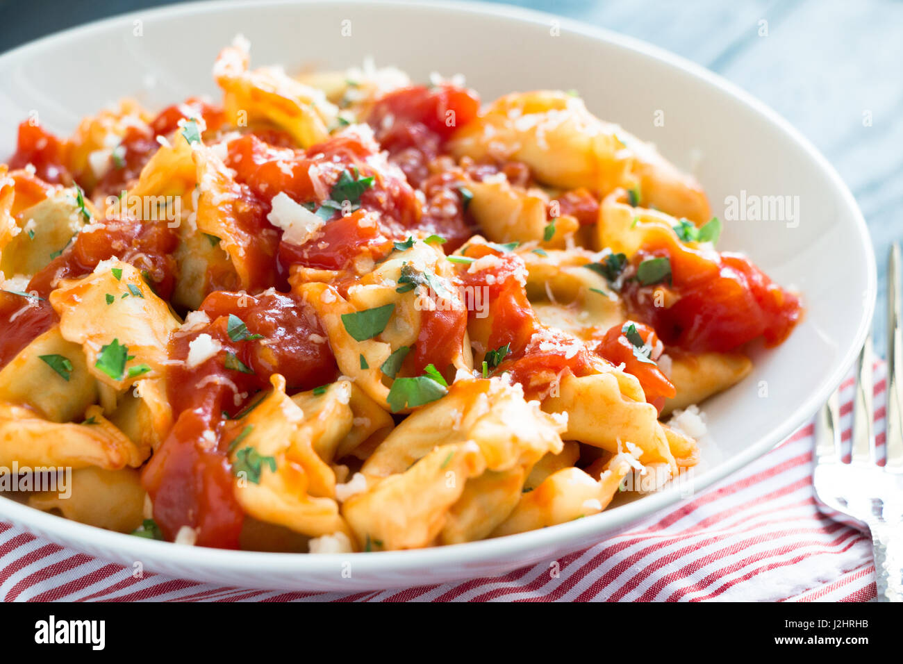 Frische Tortellini mit hausgemachter Tomatensauce, gehackten Kräutern ...