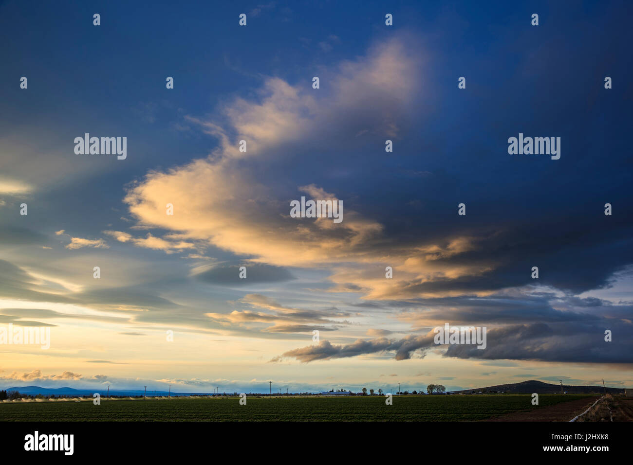 USA, Oregon, Culver, Sonnenuntergang während eines Sturms brechen über bewässerten Anbauflächen. Digital Composite, HDR Stockfoto