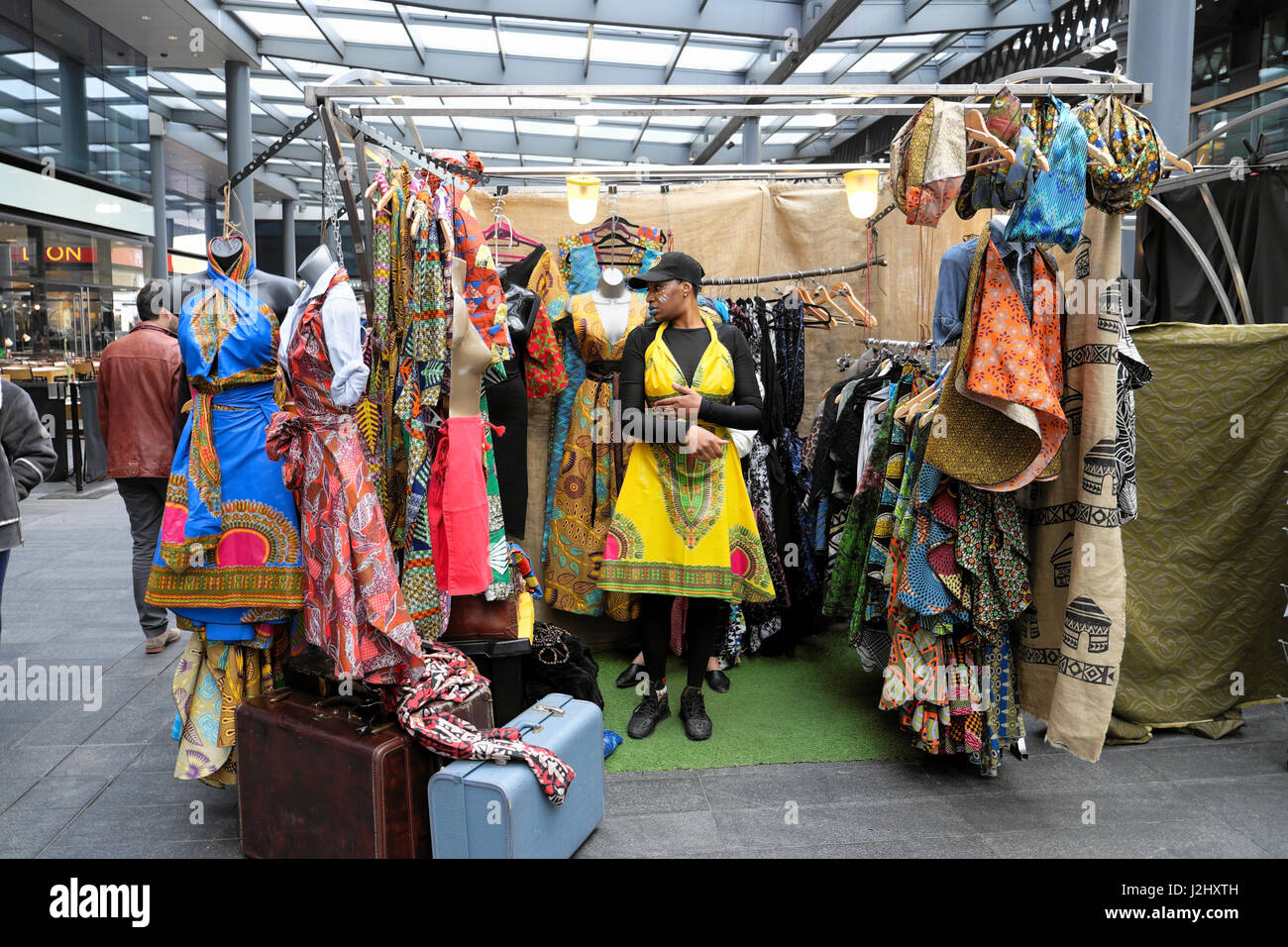 Eine hoch attraktive Frau versucht auf einem afrikanischen print Kleid in Spitalfields Market, London UK KATHY DEWITT Stockfoto