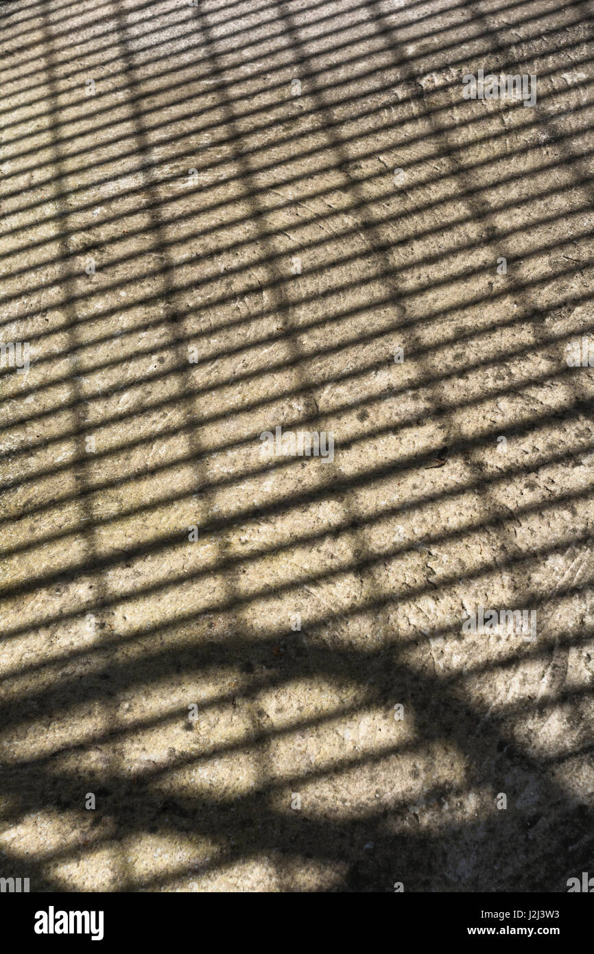 Abstrakte Schatten der Metallgitter auf Betonboden Oberfläche. Stockfoto