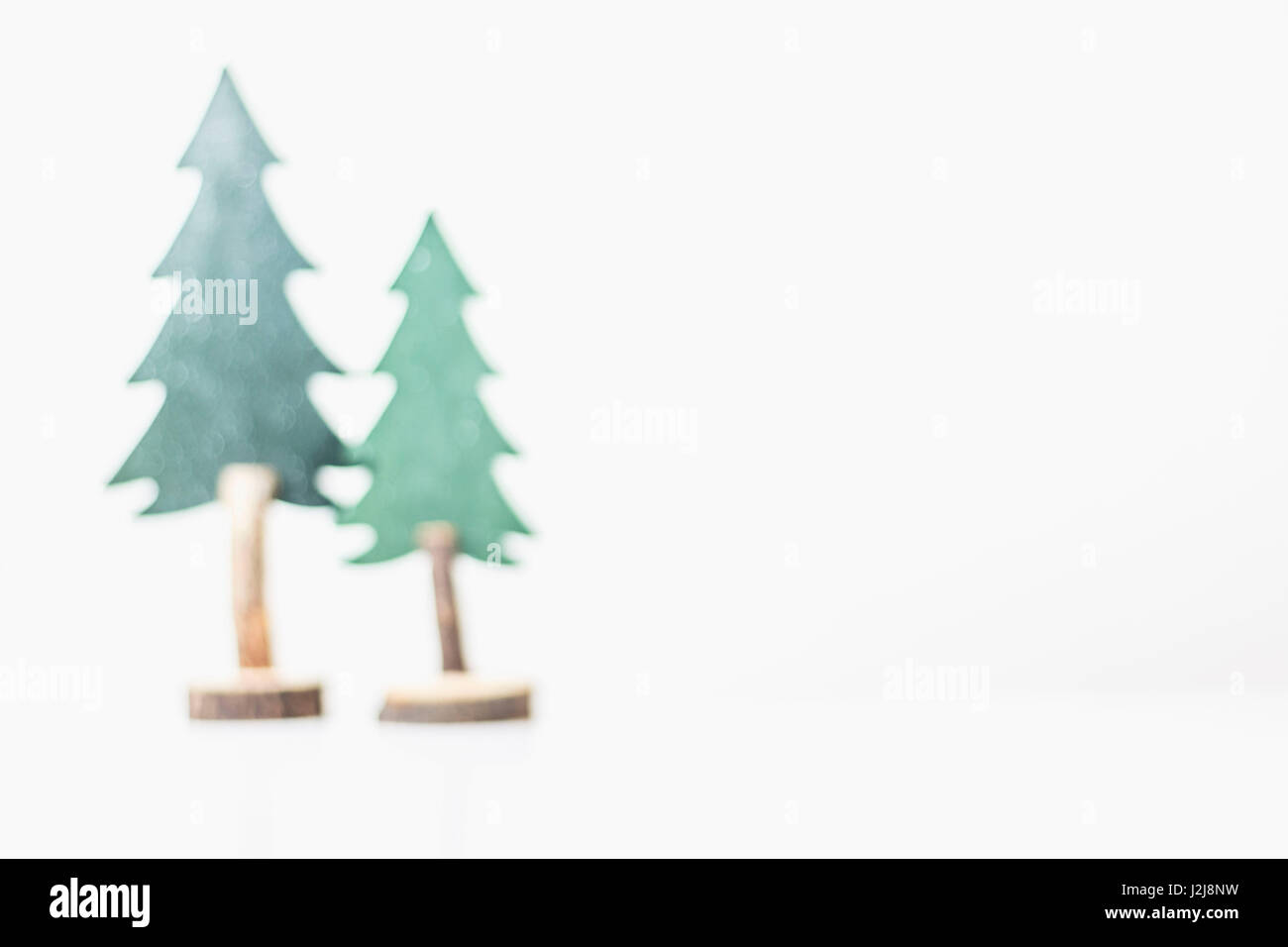 Weihnachtsdekoration, zwei Weihnachtsbäume aus Holz, hellem Hintergrund, Unschärfe Stockfoto