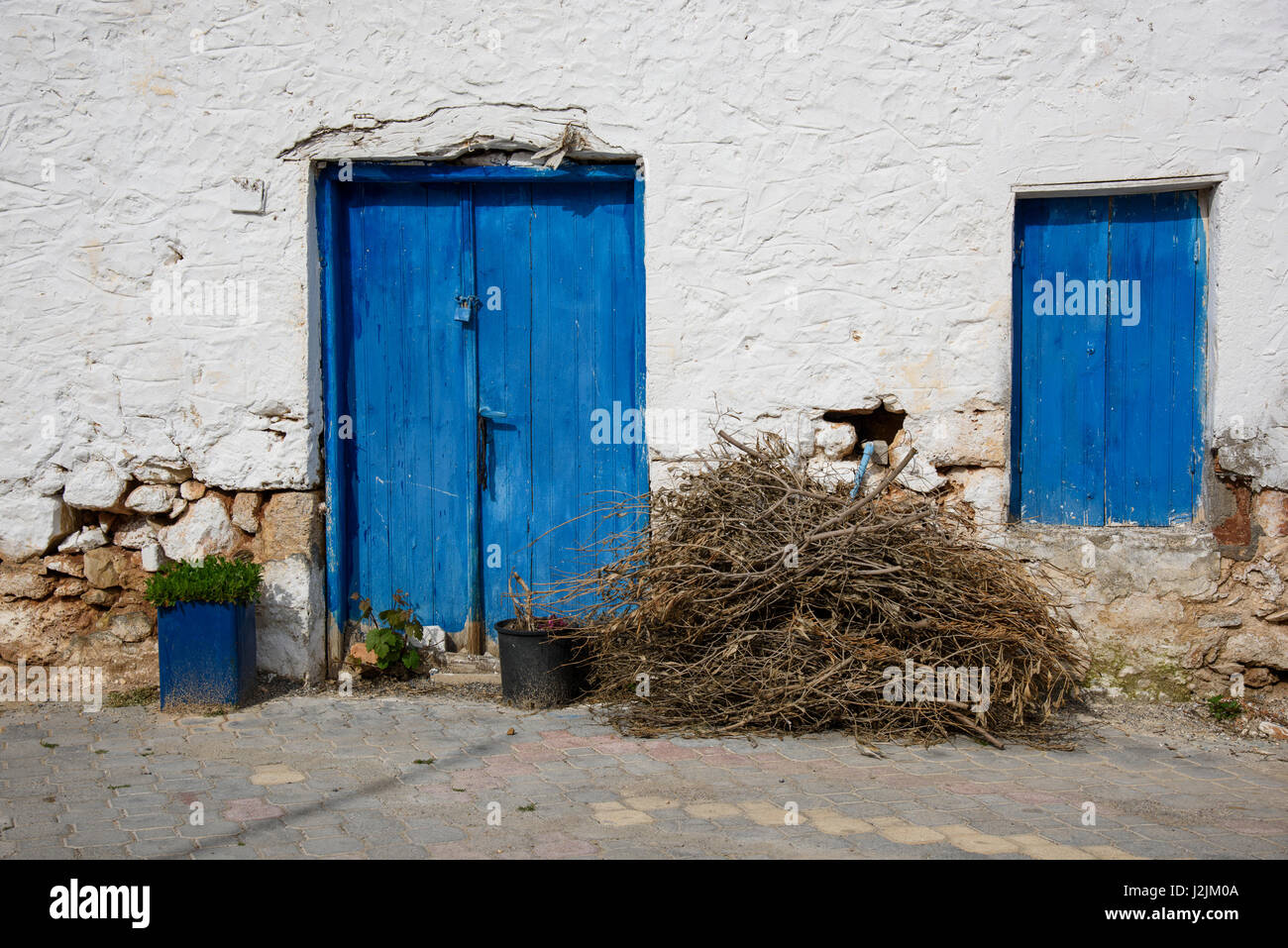 Ein Bündel von Stöcken vor einem traditionellen Haus in der griechischen Dorf Analipsi, Kreta, Griechenland. Stockfoto