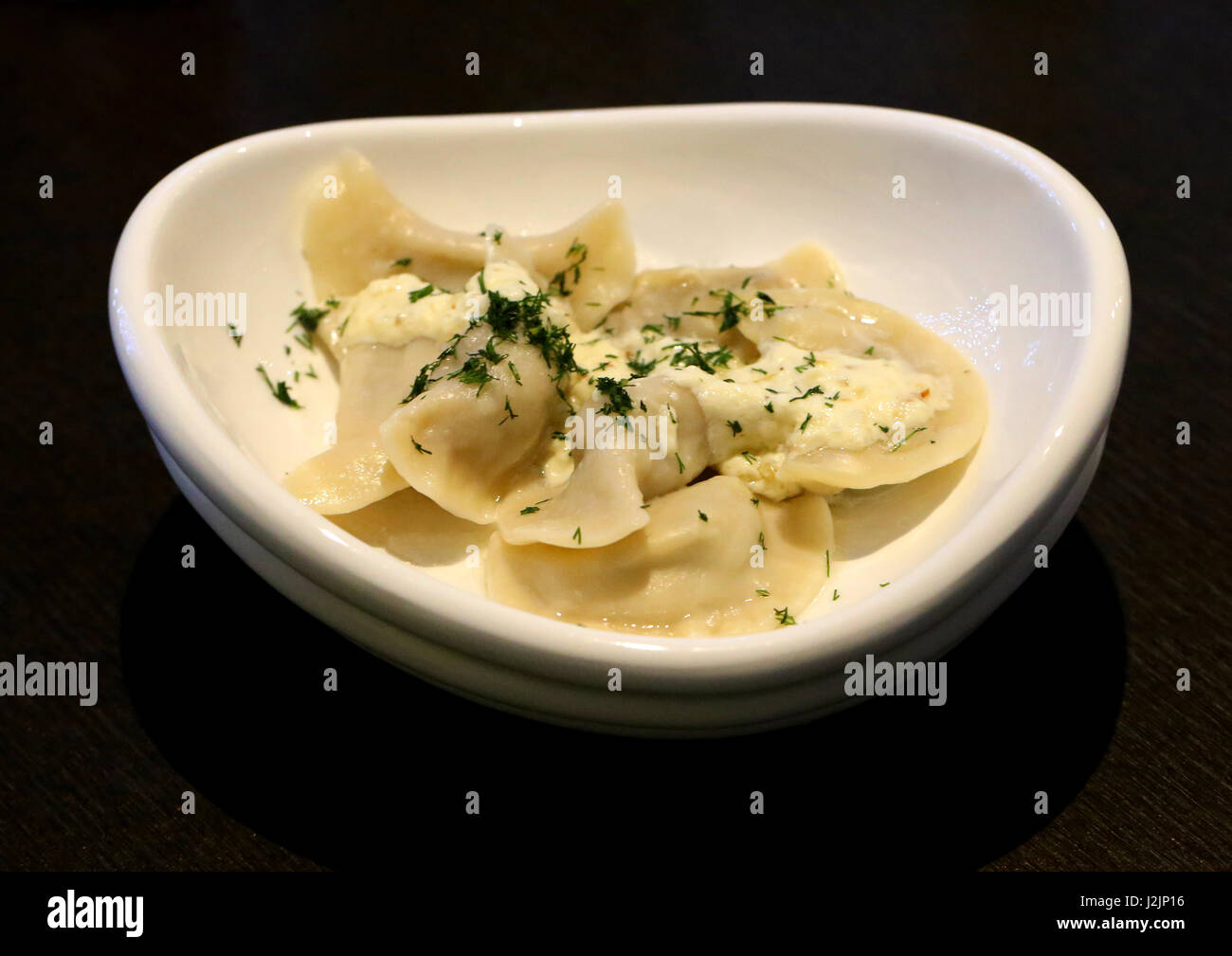Leckere Knödel mit Kartoffeln und Champignons in einem schönen weißen Teller Stockfoto