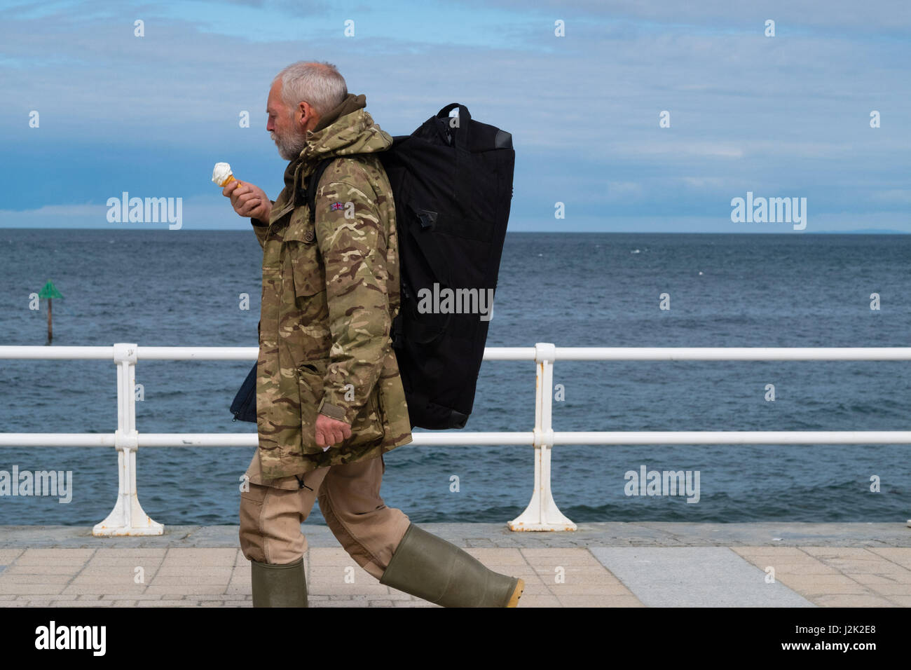 Aberystwyth Wales UK, Samstag, 29. April 2017 UK Wetter - ein Mann genießen ein Eis einen hellen sonnigen, aber windigen Morgen am Meer in Aberystwyth zu Beginn der Mayday Bank Holiday Wochenende Photo Credit: Keith Morris/Alamy Live-Nachrichten Stockfoto