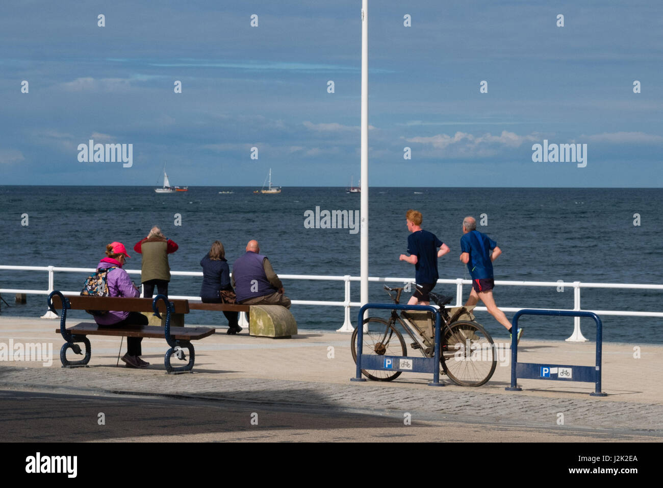 Aberystwyth Wales UK, Samstag, 29. April 2017 UK Wetter - Menschen genießen einen hellen sonnigen, aber windigen Morgen am Meer in Aberystwyth zu Beginn der Mayday Bank Holiday Wochenende Photo Credit: Keith Morris/Alamy Live-Nachrichten Stockfoto
