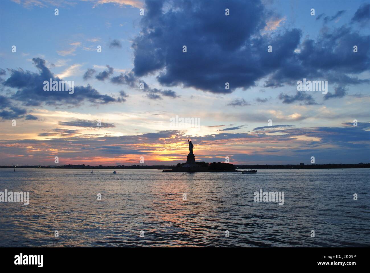 Freiheitsstatue mit einem dramatischen Sonnenuntergang hinter beste Reiseziel New York, Vereinigte Staaten Stockfoto