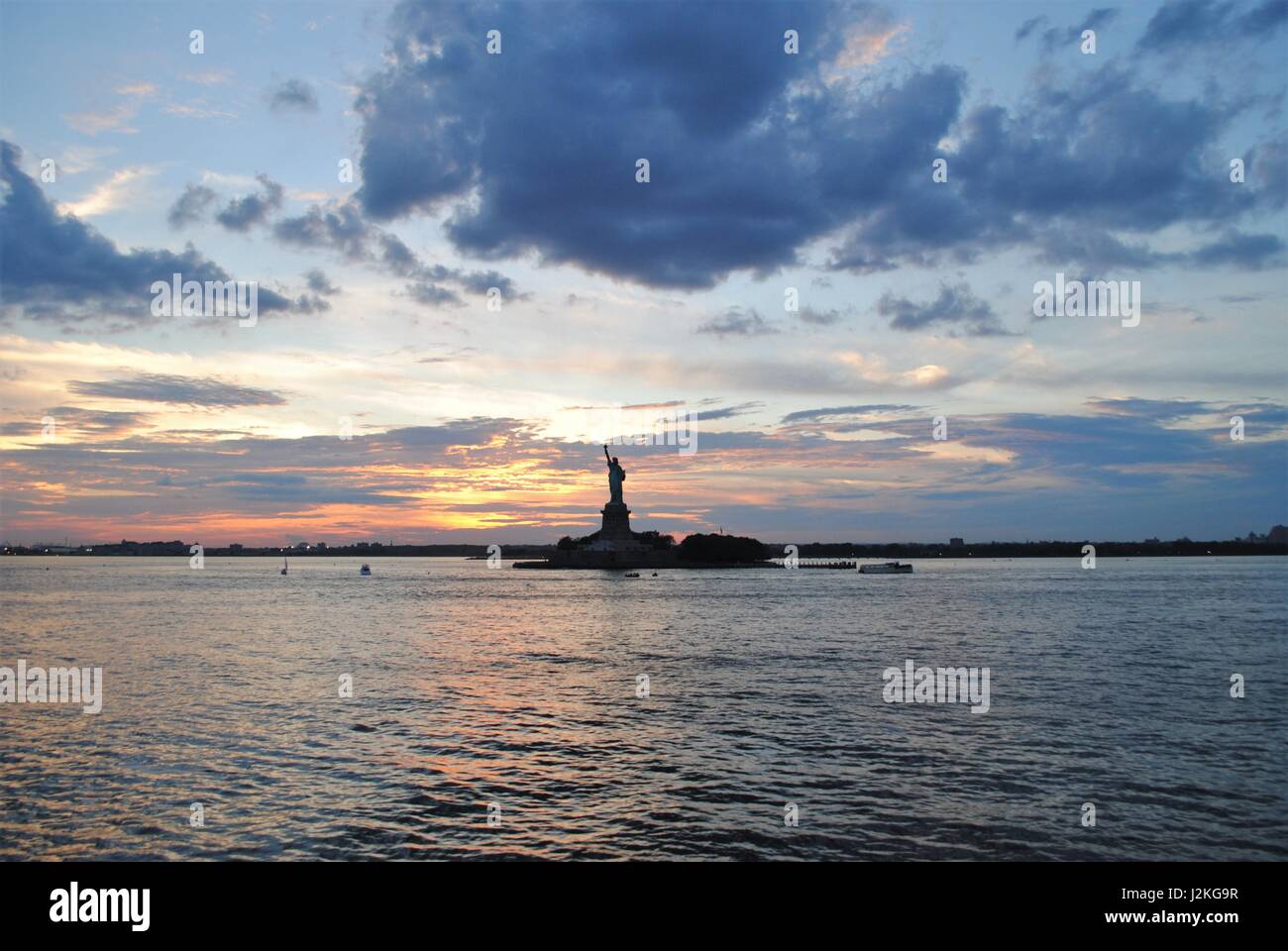 Freiheitsstatue mit einem dramatischen Sonnenuntergang hinter beste Reiseziel New York, Vereinigte Staaten Stockfoto
