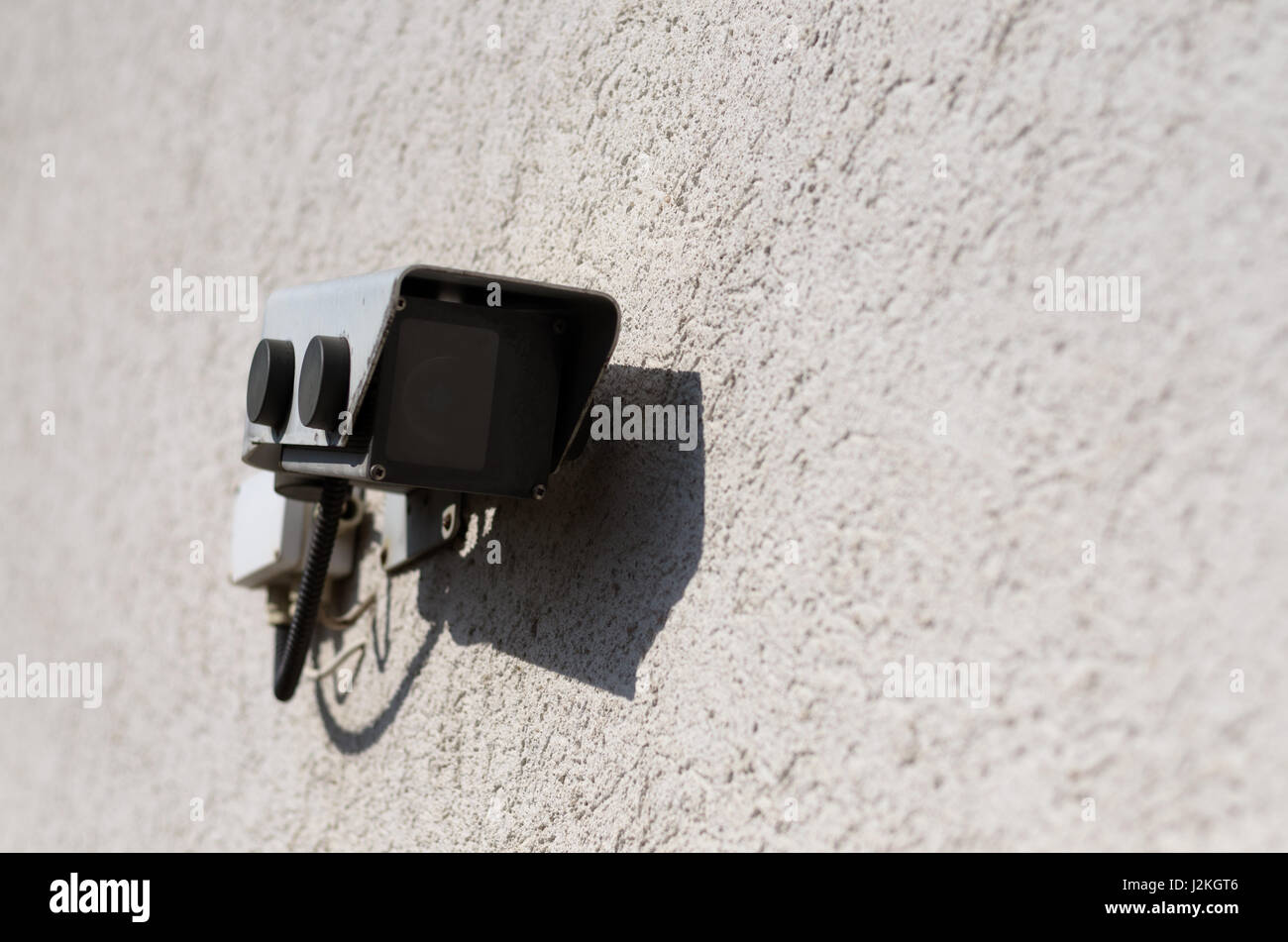 Geschlossenen Kreislauf Sicherheit und Überwachung Kamera montiert auf einer groben Besetzung verputzten Wand bei Sonnenschein mit textfreiraum neben Stockfoto