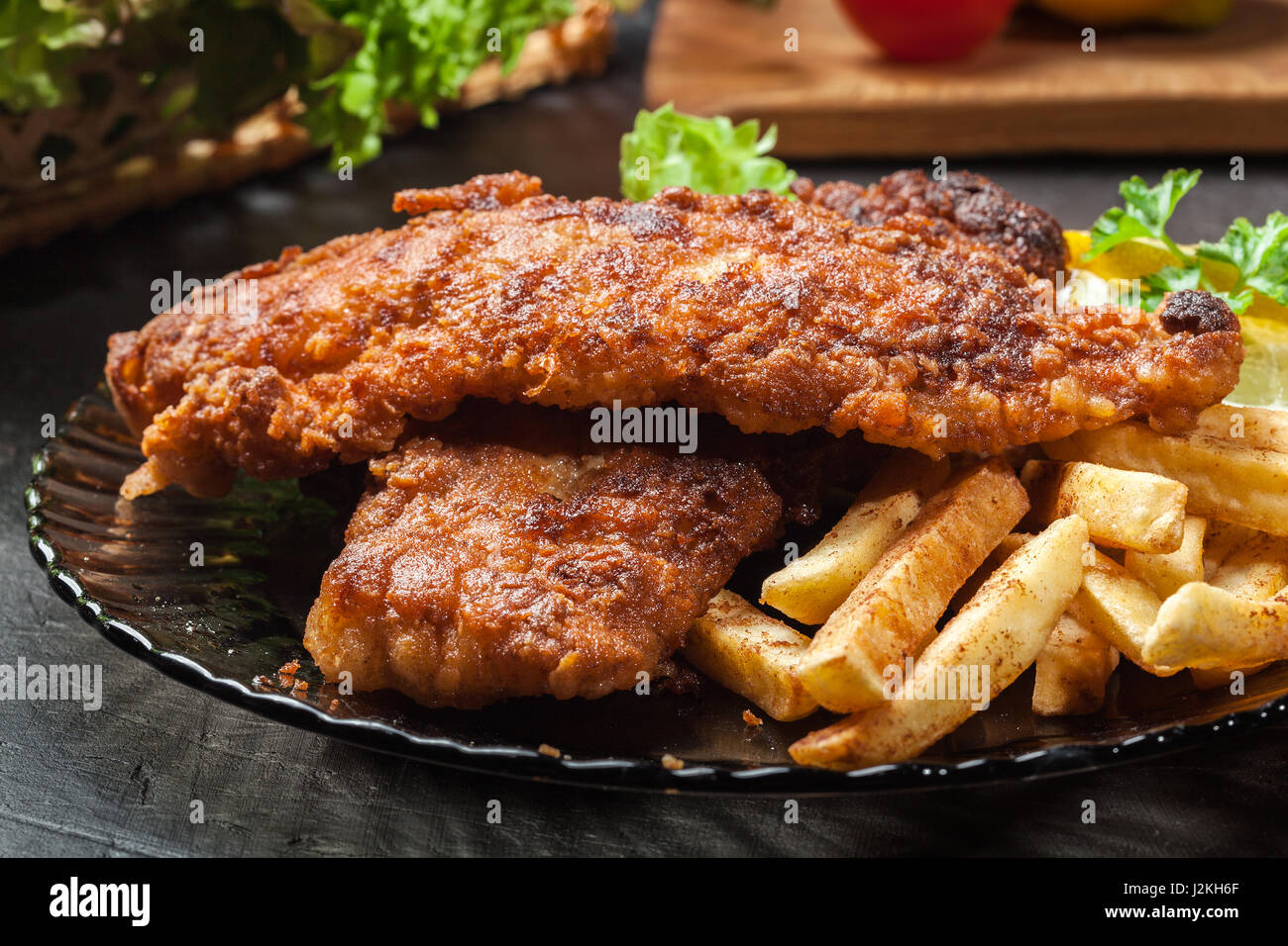 Gebratener Fisch in knuspriger Teig mit Chips auf einem Teller Stockfoto