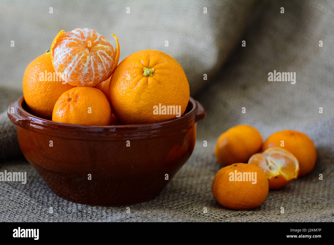 Nahaufnahme einer Schale von Orangen und Mandarinen auf einem rustikalen Hintergrund Stockfoto
