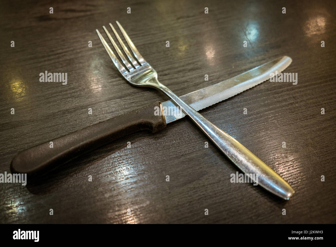 Gabel und Messer auf Holztisch. Stockfoto