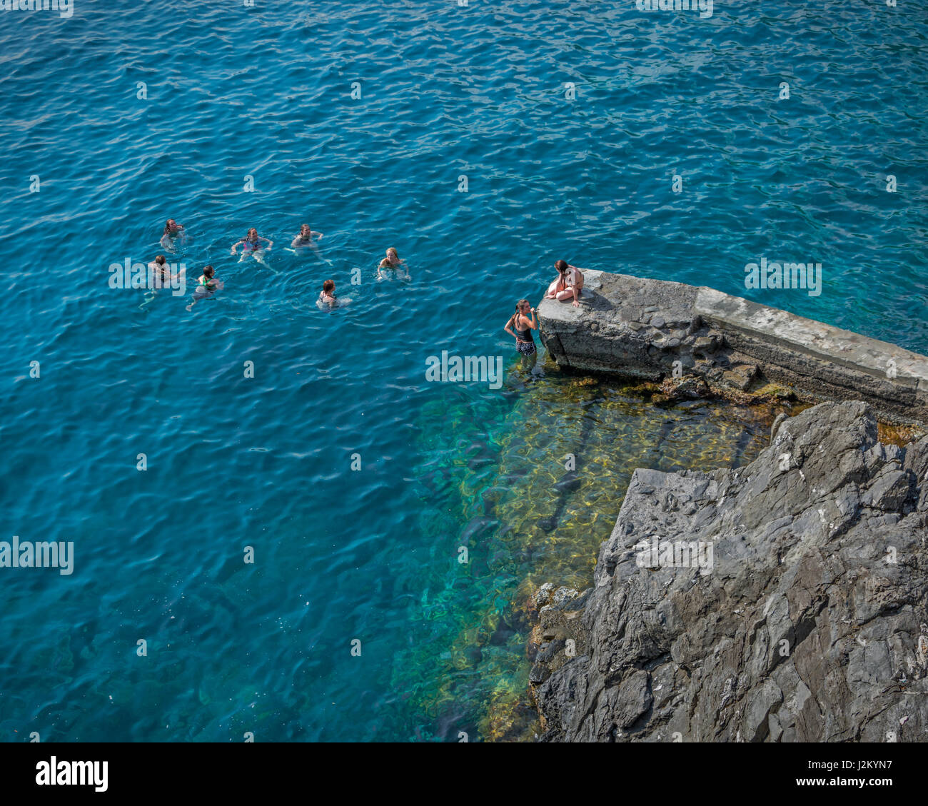 Eine Gruppe von Mädchen Schwimmen im Kreis im Hafen von Cinque Terre Dorf Manarola in Ligurien, Italien Stockfoto