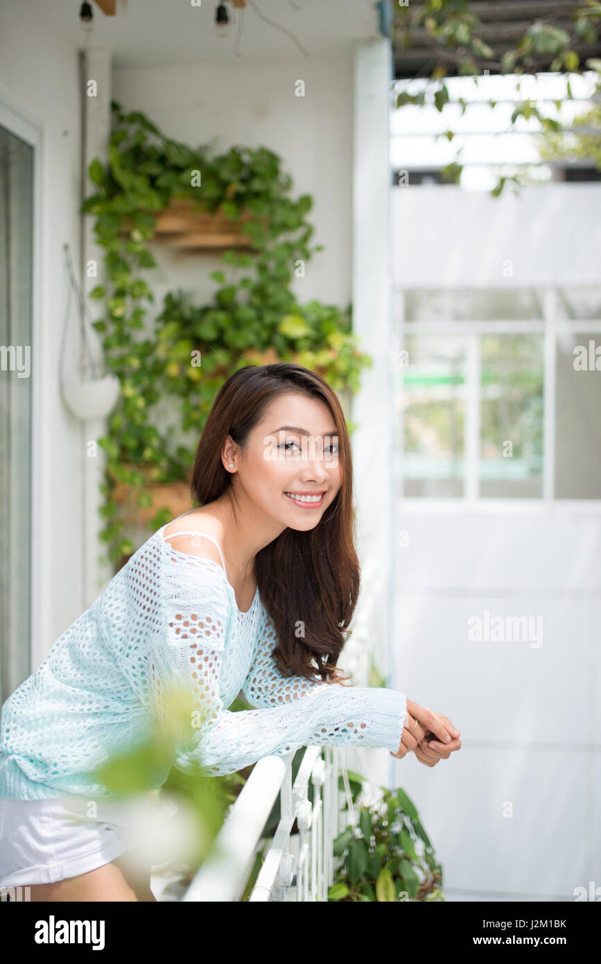 Asiatische Frau, die an der frischen Luft zu Hause Stockfoto