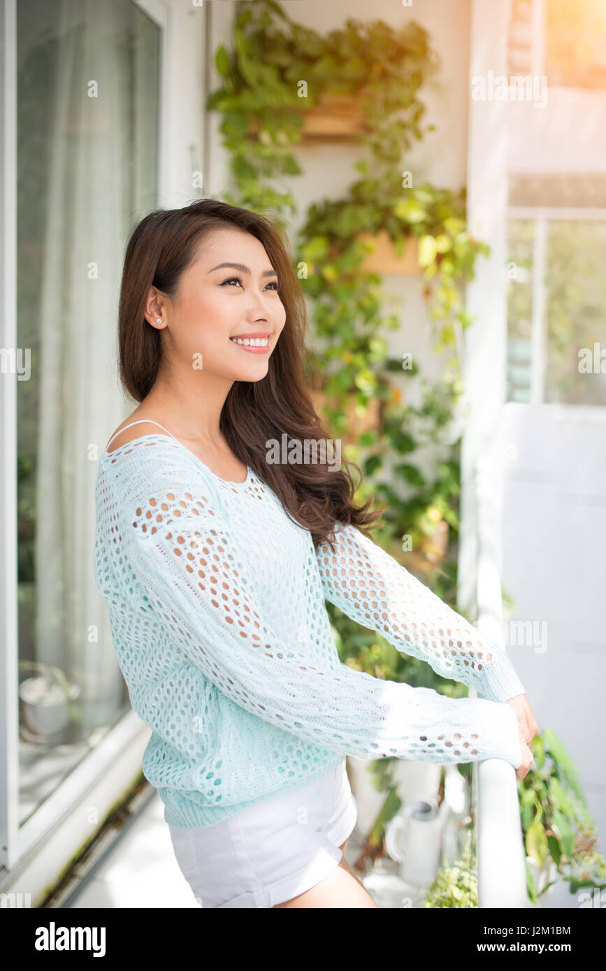 Asiatische Frau, die an der frischen Luft zu Hause Stockfoto