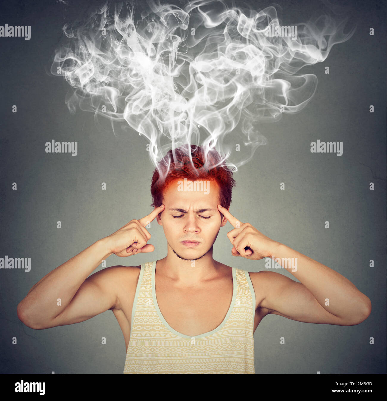 Mann denkt sehr intensiv mit Kopfschmerzen auf graue Wand Hintergrund isoliert Stockfoto