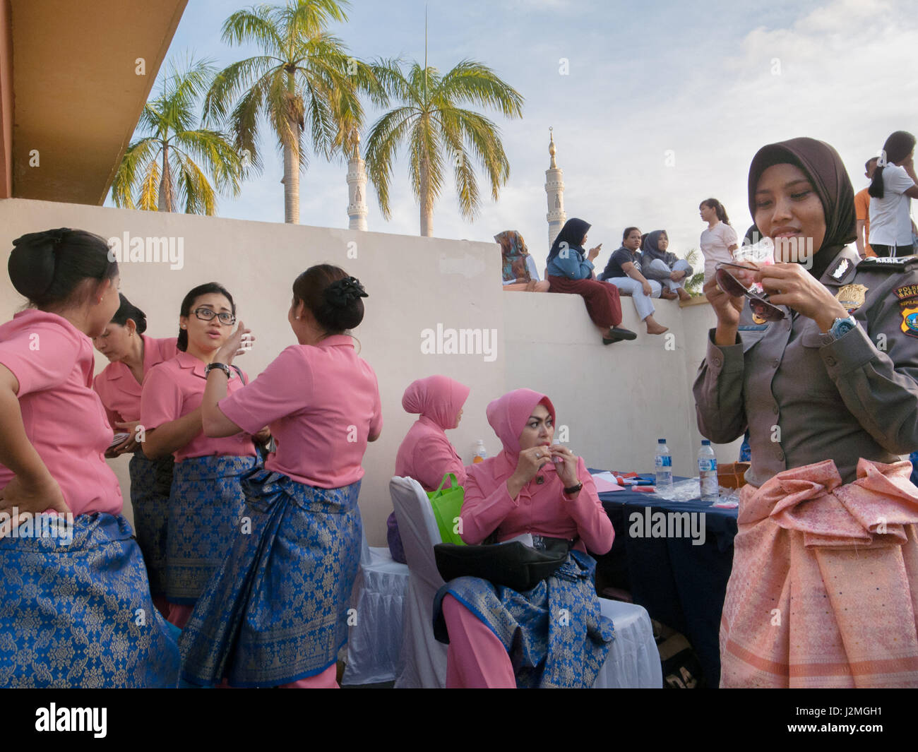 BATAM, INDONESIEN. Frauen in rosa Uniform sprechen während der andere ihre Hütten auf dem Platz genossen. Stockfoto