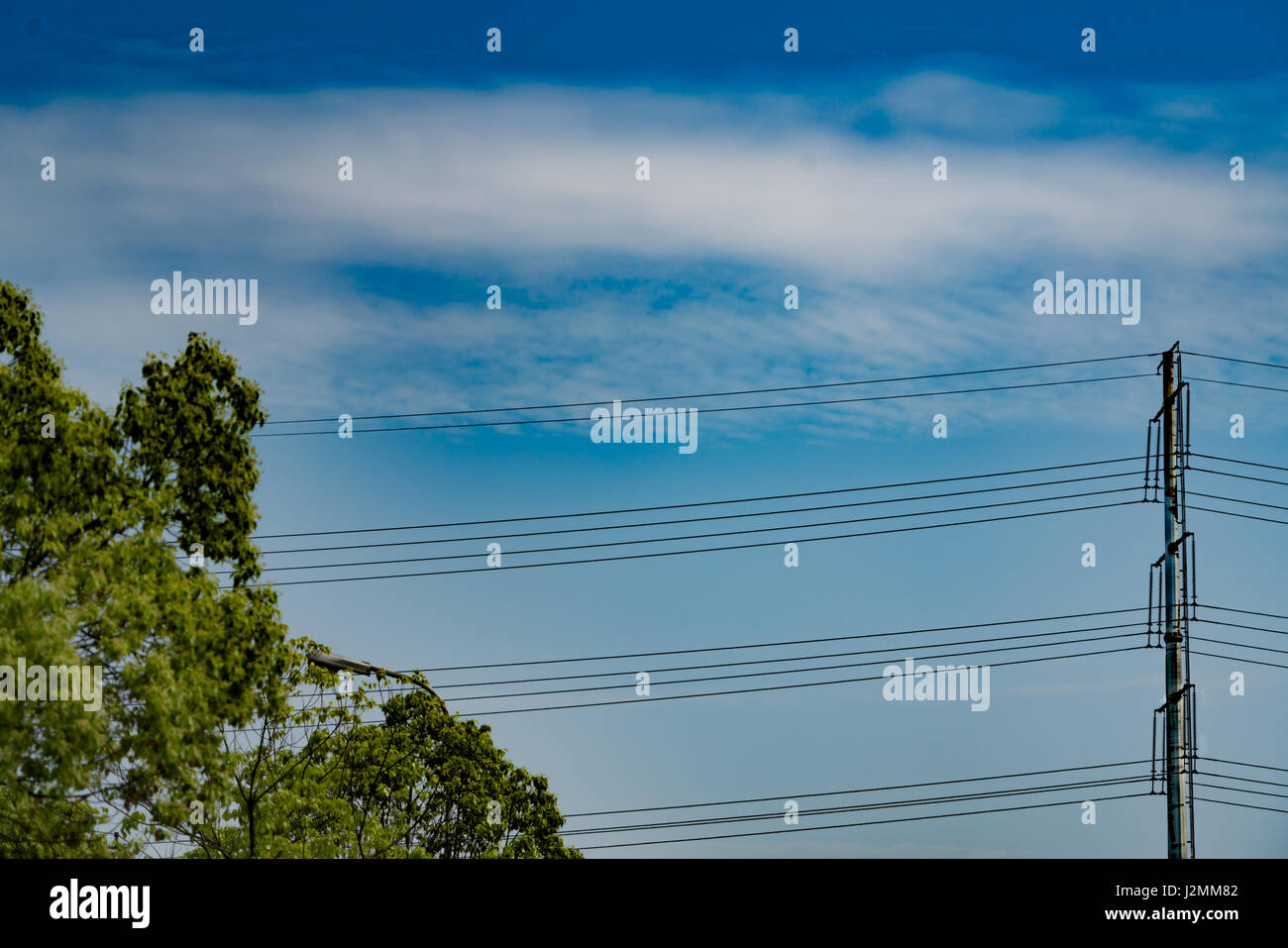 blauer Himmel an sonnigen Tag mit Hochspannung Stromversorgung Pol Stockfoto