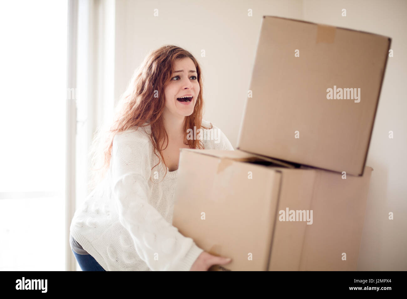 Rothaarige Frau Umzug Karton Kisten fallen Stockfoto