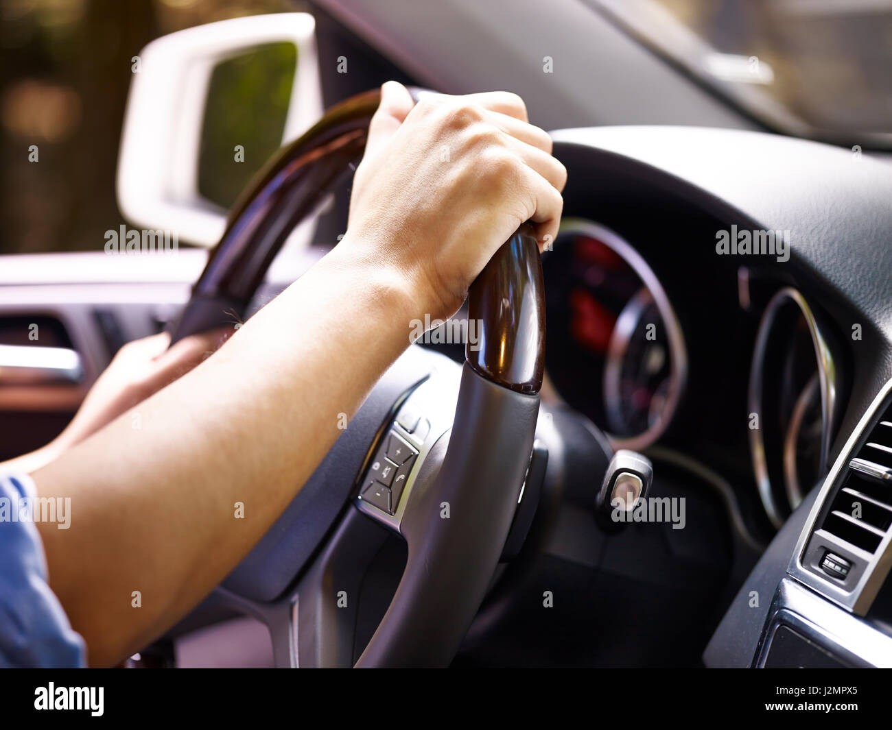 Hände von einem männlichen Fahrer mit Lenkrad eines Fahrzeugs, close-up. Stockfoto