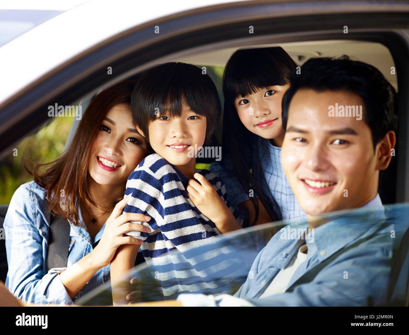 glückliche asiatischen Familie mit zwei Kindern reisen mit dem Auto, der kleine Junge im Mittelpunkt. Stockfoto