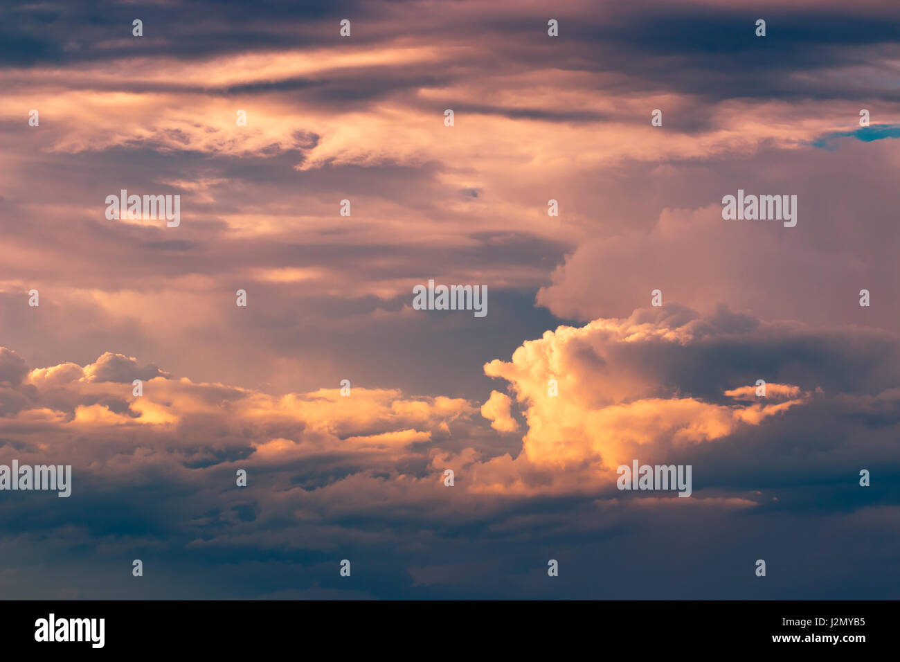 Orange flauschig Flecken von Wolken gegen den tiefblauen Himmel bei Sonnenuntergang, Farbe verbessert Stockfoto