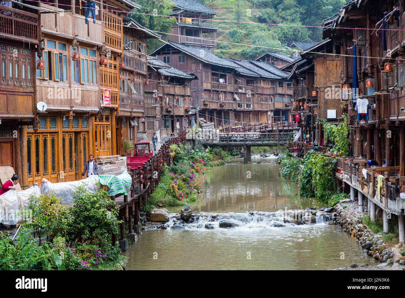 Zhaoxing, Guizhou, China, ein Dong Minderheit Dorf.  Geschäfte und Häuser Linie Seiten der kleine Fluss, der durch das Dorf. Stockfoto