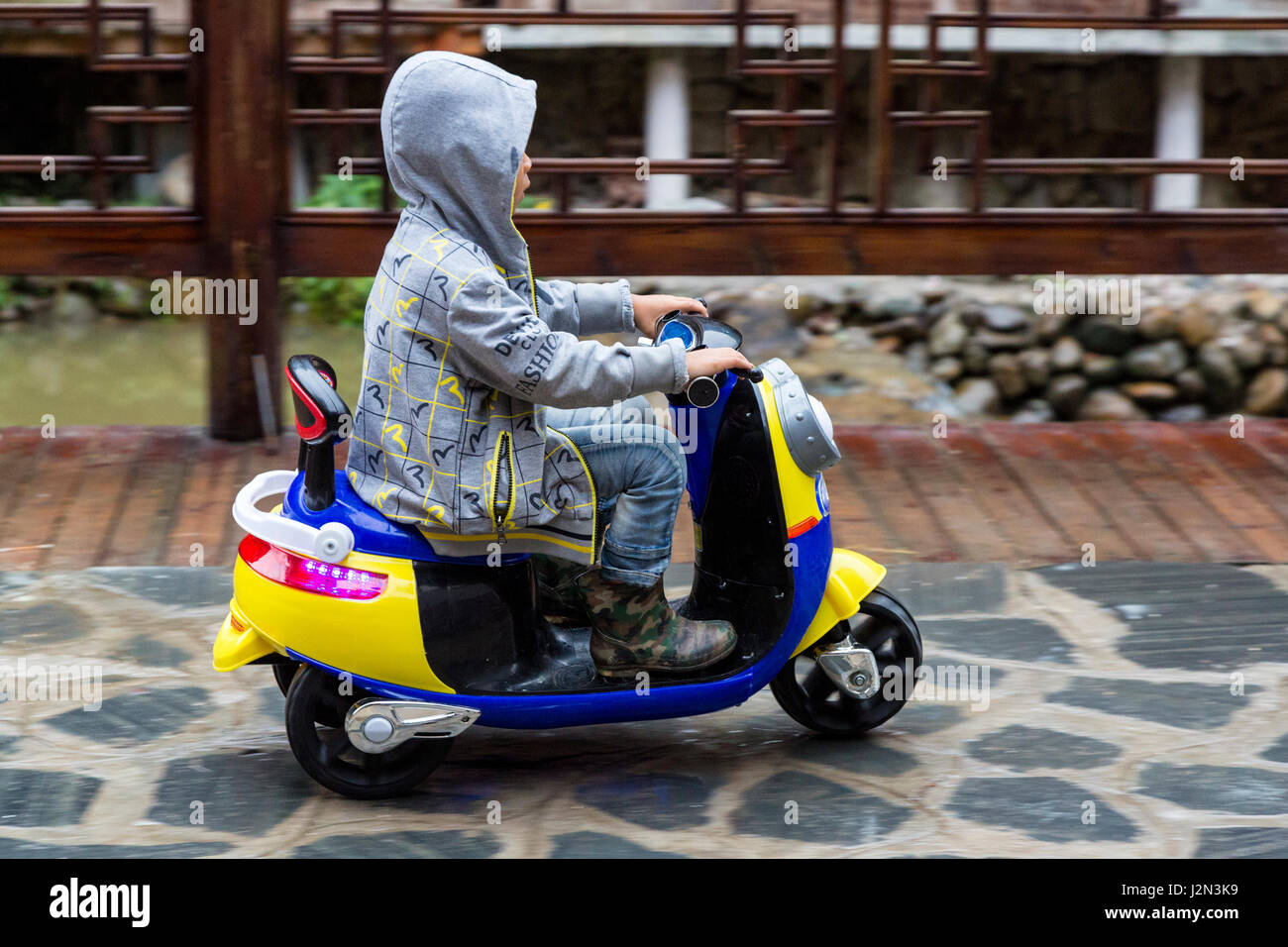 Zhaoxing, Guizhou, China, ein Dong Minderheit Dorf.  Junge, ein Dreirad-Motorroller. Stockfoto