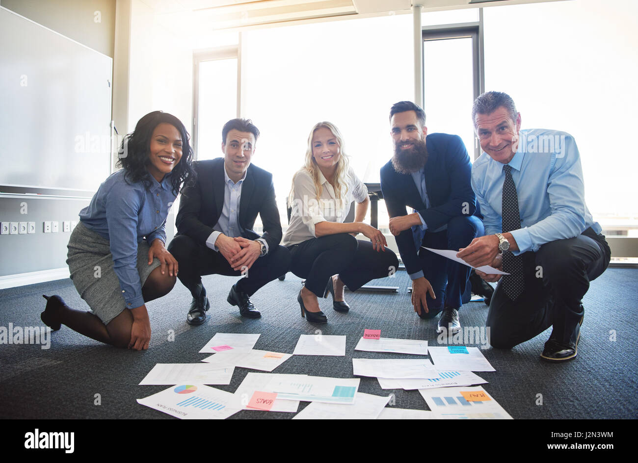 Lächelnd Business-Team mit Ideen ausgebreitet auf Büroetage Stockfoto