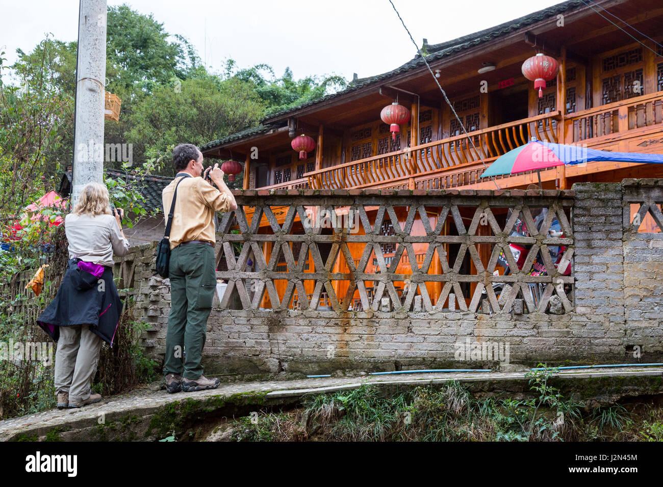 Matang, einem Gejia Dorf in Guizhou, China.  Touristen fotografieren Dorfhaus. Stockfoto