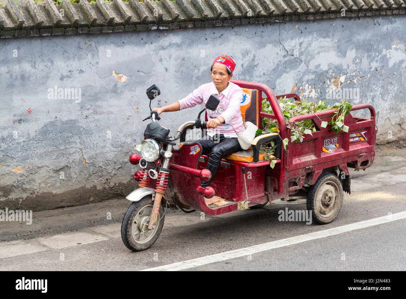 Kaili, Guizhou, China.  Autofahrerin kleine Cargo Dreirad-Transporter. Stockfoto