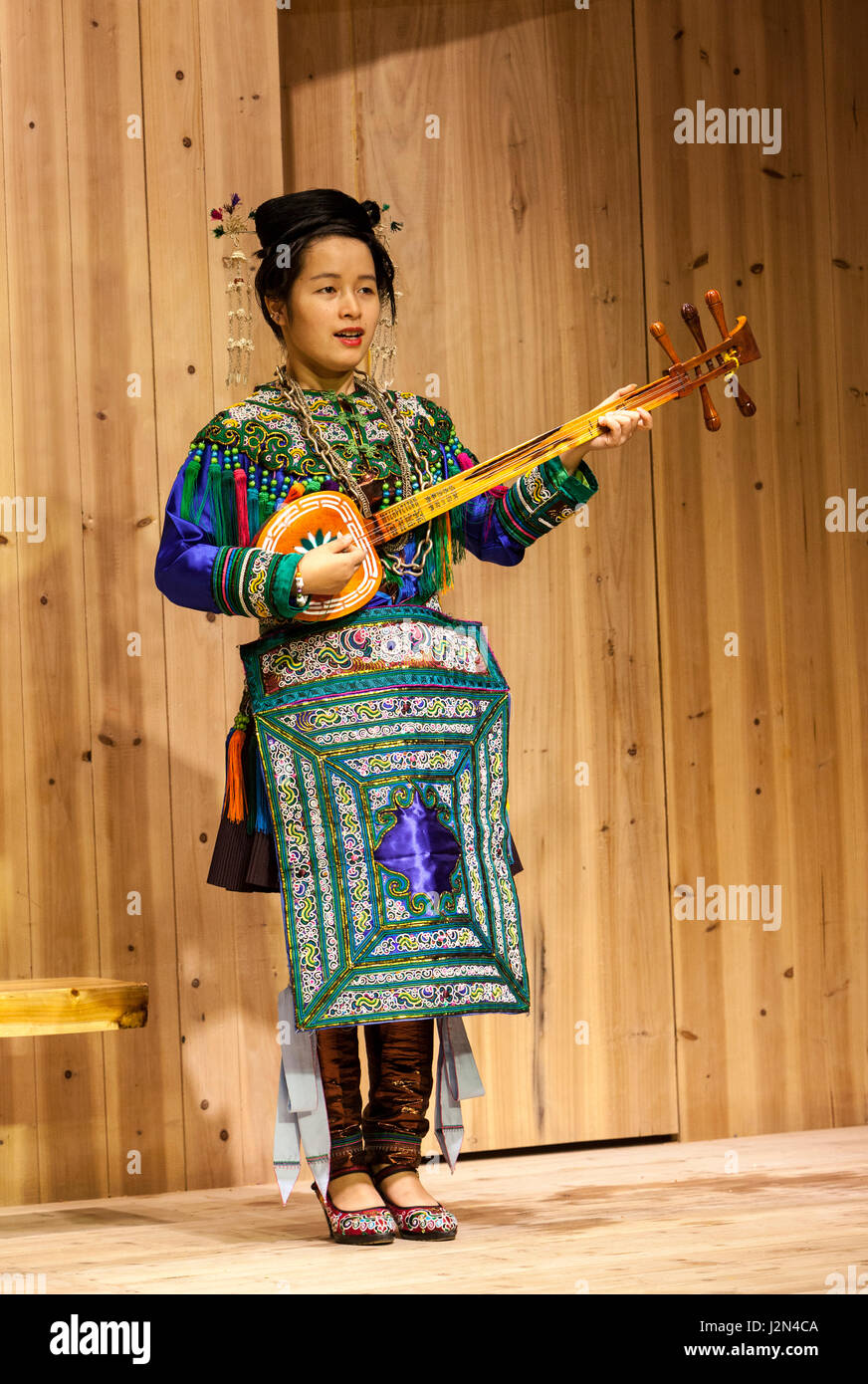 Zhaoxing, Guizhou, China.  Junge Frau von der Dong ethnische Minderheit spielt eine fünf-saitige laute (Pipa). Stockfoto