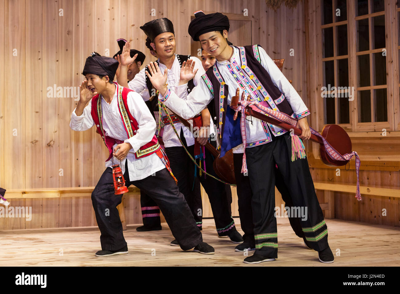 Zhaoxing, Guizhou, China.  Junge Männer handeln eine Geschichte in einer traditionellen musikalischen Darbietung von den Mitgliedern der ethnischen Minderheit Dong. Stockfoto