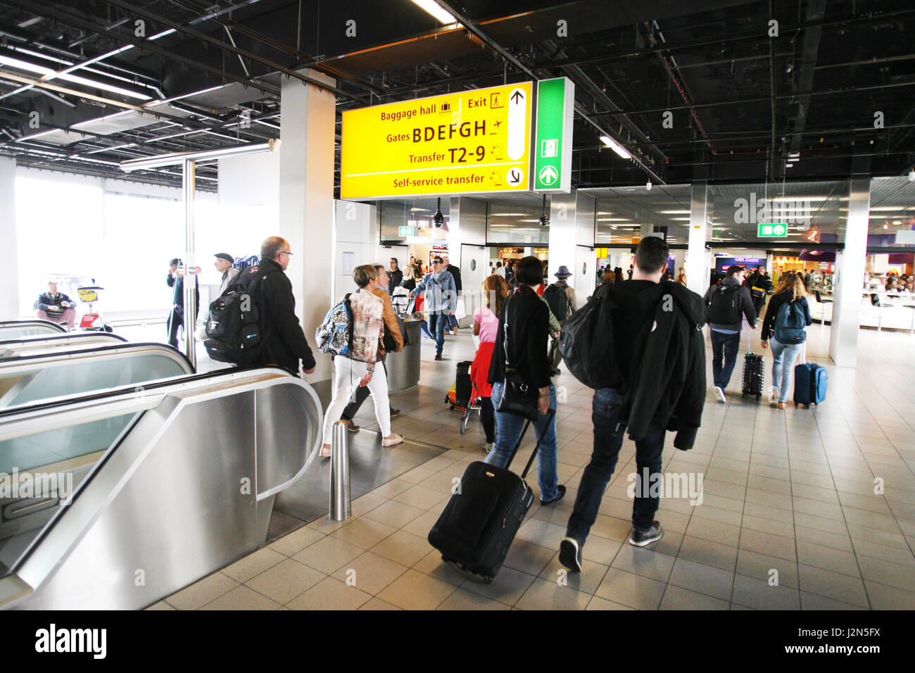 Reisende sind am 29. April 2017 in der Ankunftshalle am Flughafen Schiphol in Amsterdam, Niederlande gesehen. Schiphol ist der größte internationale Flughafen der Stockfoto