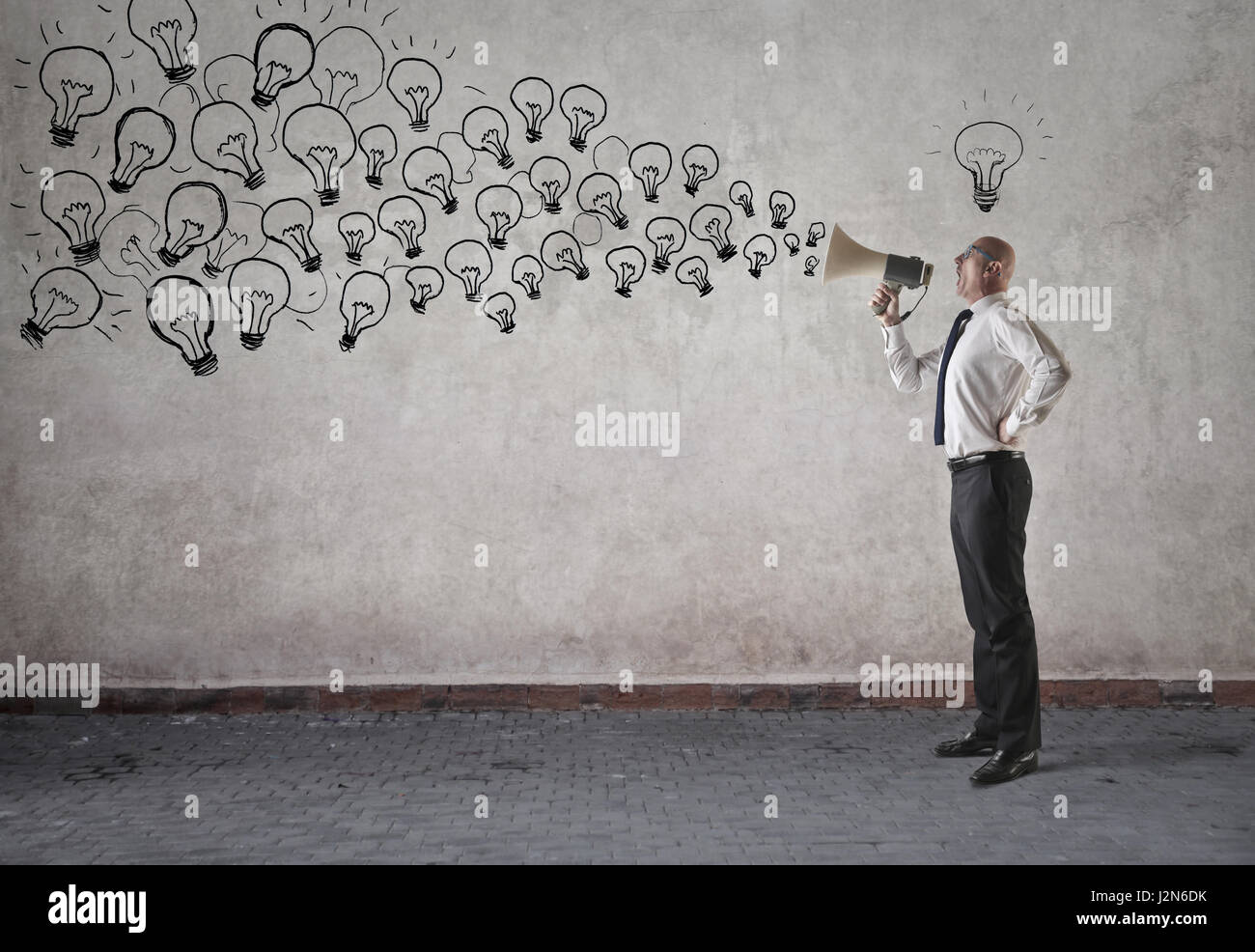 Geschäftsmann mit Megaphon platzen aus Glühbirnen Stockfoto