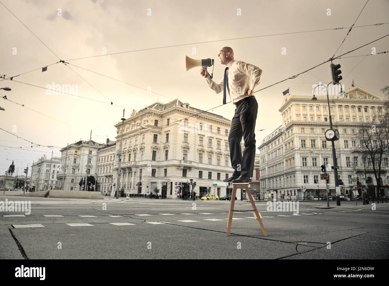 Geschäftsmann mit Megaphon auf der Straße Stockfoto