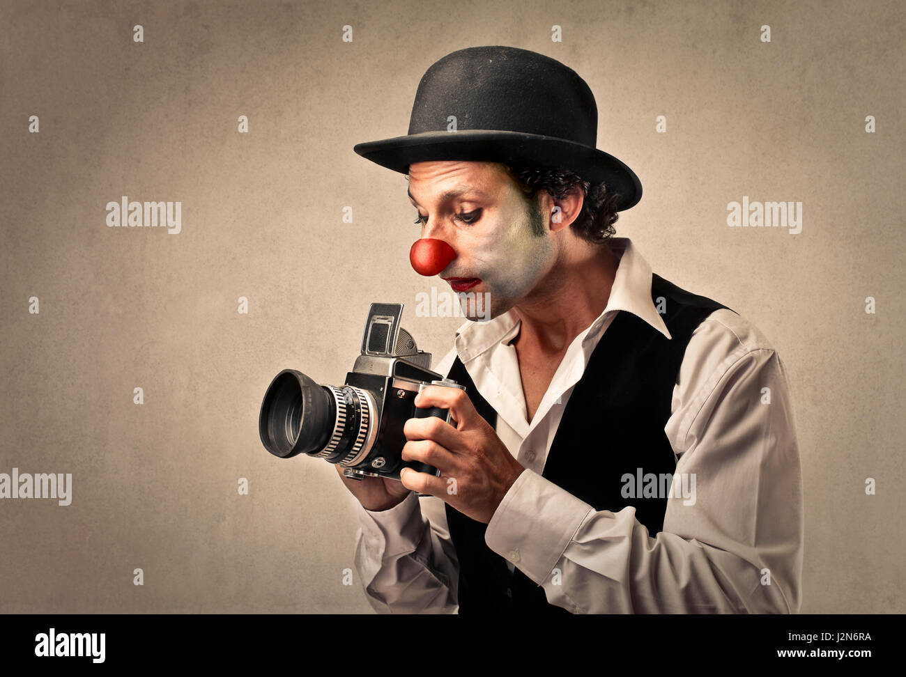 Clown-Mann mit professioneller Kamera Stockfoto