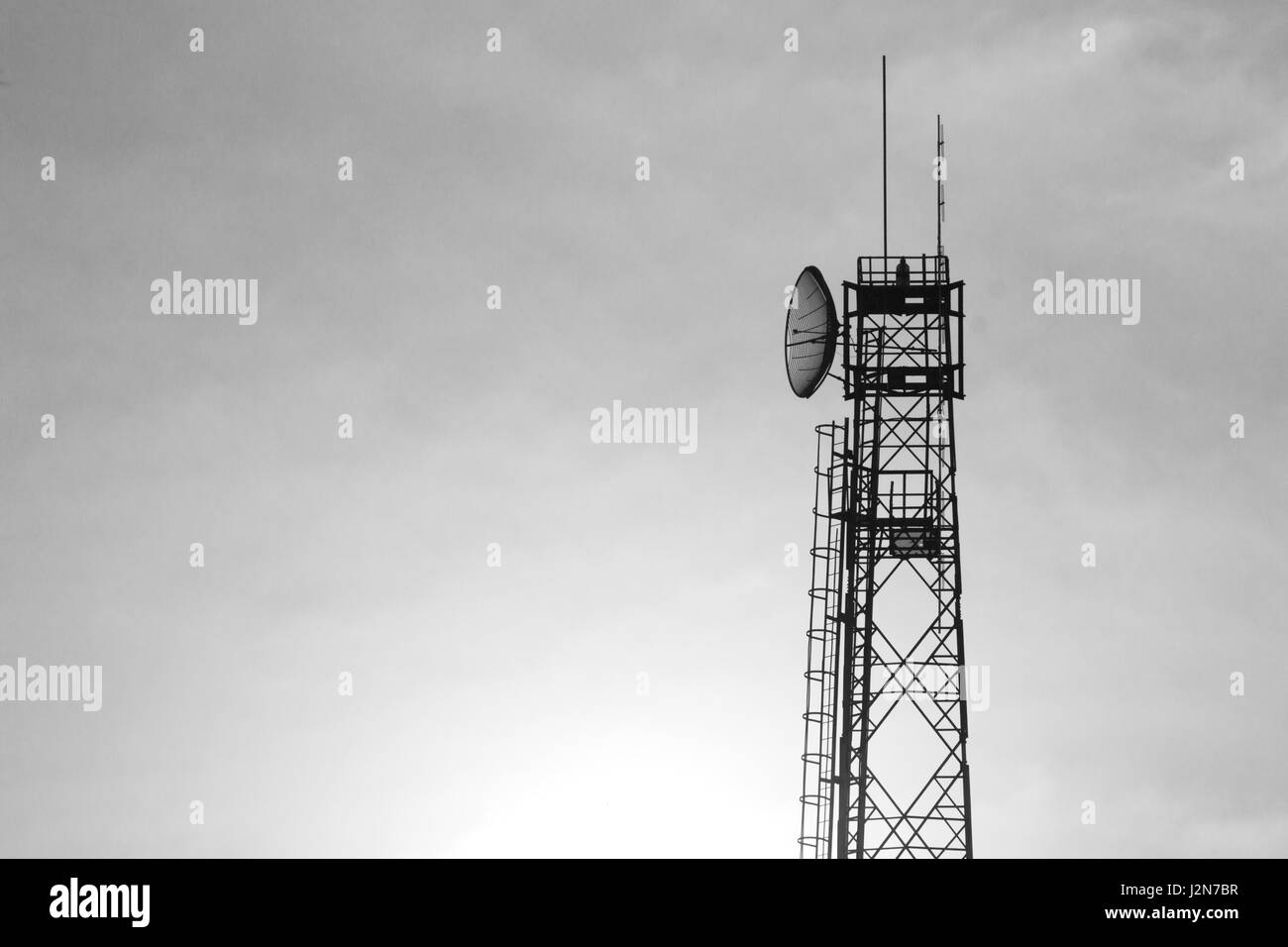Kommunikation-Turm gegen die warme Farbe der Sonnenaufgang am Morgen mit weich fließenden flauschigen Wolken Stockfoto
