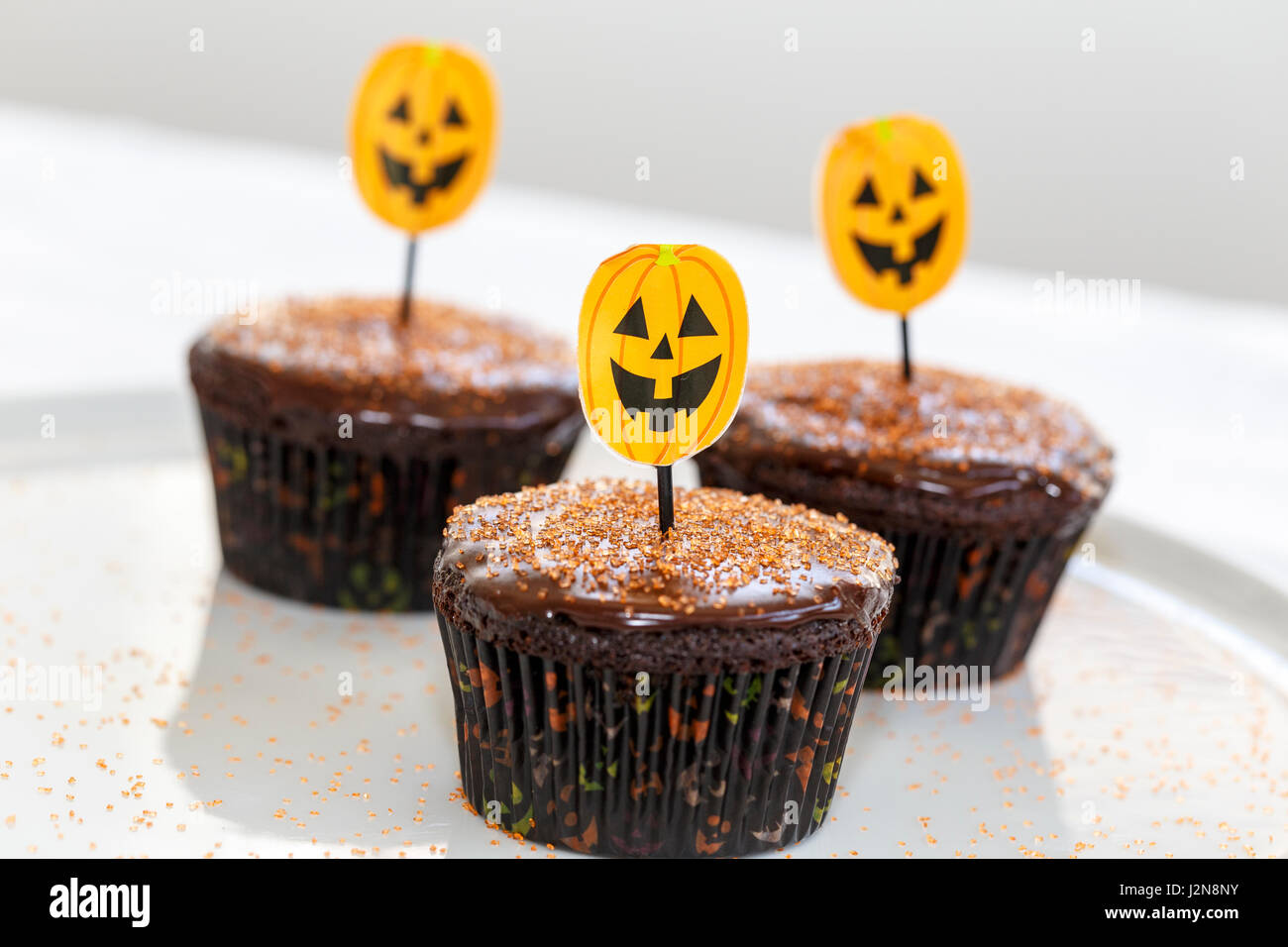 Halloween-Schokoladentörtchen mit orange Dekorationen Stockfoto
