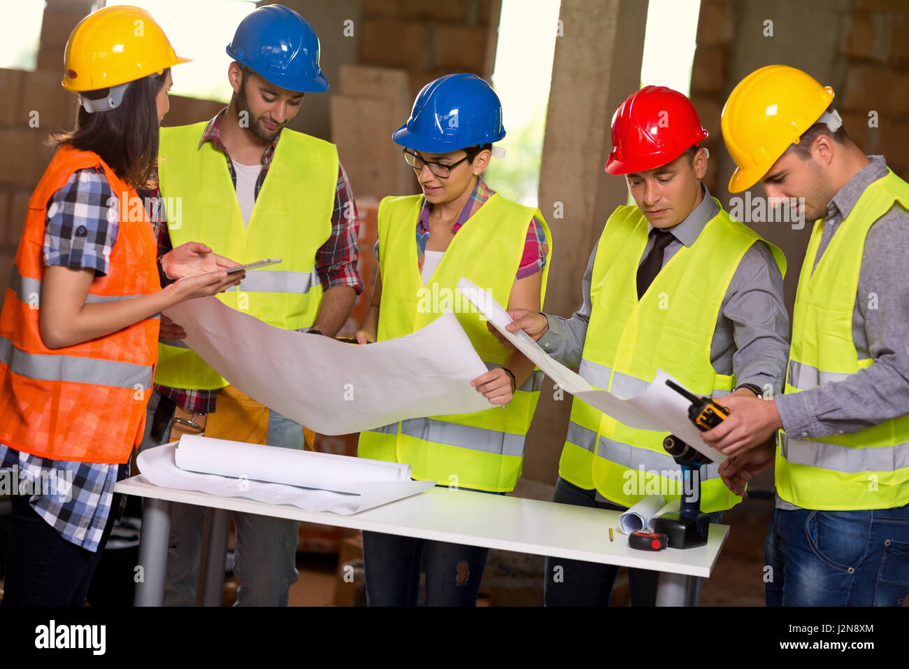 Gruppe von Architekten und Bauarbeiter auf der Baustelle mit Blaupause Stockfoto