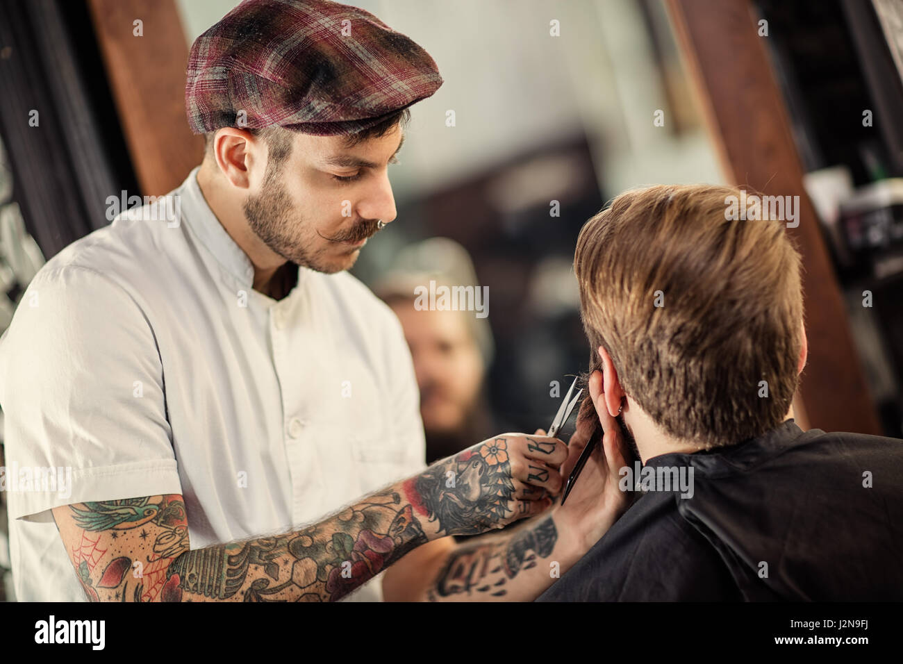 Friseur mit einer Schere schneiden Sie den Bart des Clients hautnah Stockfoto