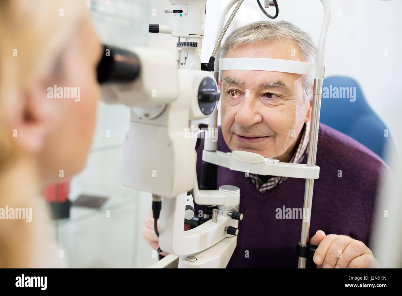 Junge weibliche Augenarzt bestimmt Abstand der Augen Schüler für Patienten Stockfoto