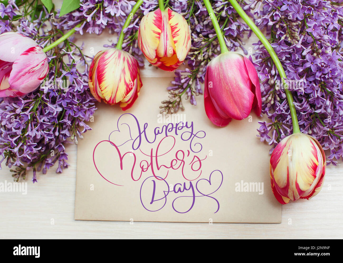 Rahmen von Tulpen und Flieder und Text Happy Muttertag. Kalligraphie-Schriftzug Hand zeichnen Stockfoto